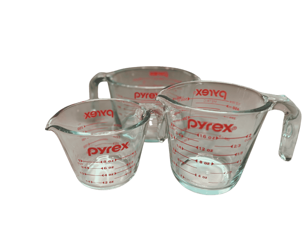 Set of three clear glass Pyrex measuring cups with red measurement markings