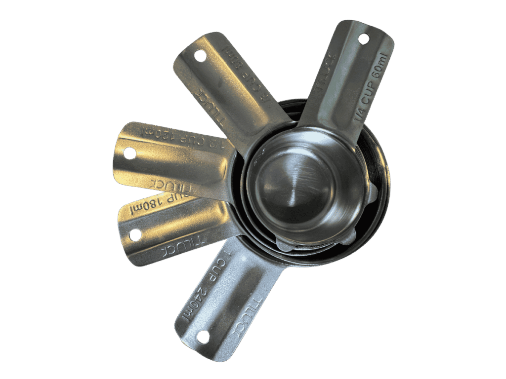Set of stainless steel measuring cups fanned out with volume markings